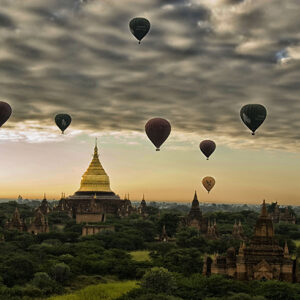 Hot air balloons floating over ancient temples during sunrise in Bagan, Myanmar.