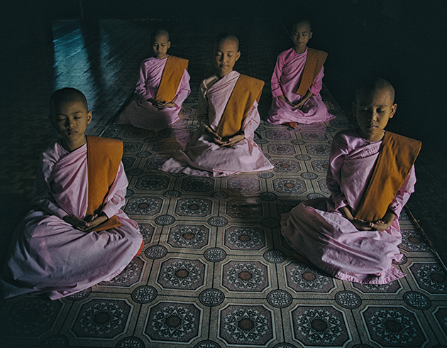 Young Buddhist nuns meditating in a serene setting in Sagaing, Myanmar